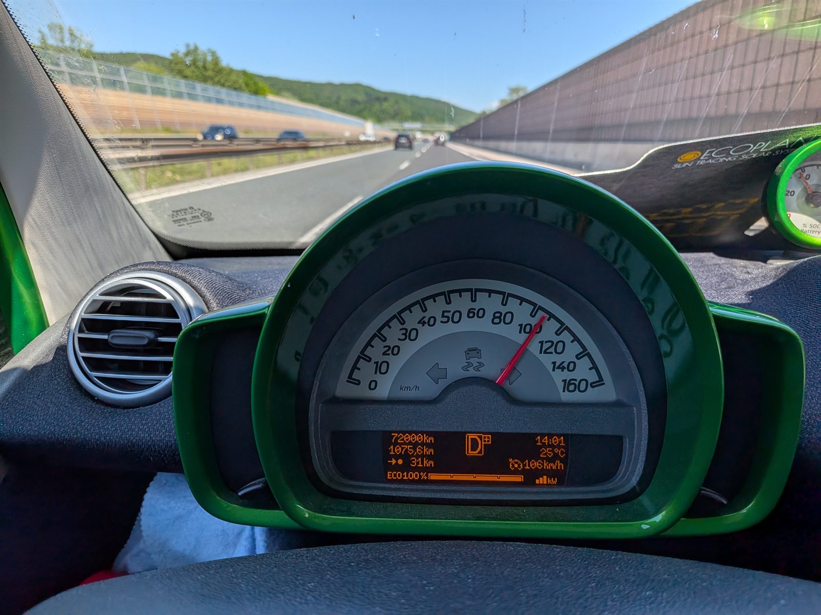The smart ED's green instrument cluster on the motorway showing 106 km/h and a 1075 km trip counter